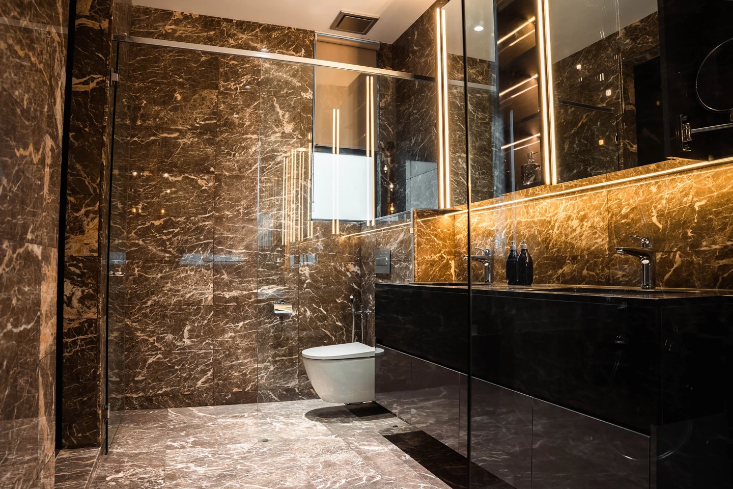 Bathroom design with wet and dry areas separated by a frameless glass partition — marble shower wall and wall-hung toilet in a Cyberjaya master bathroom, Setia Marina One