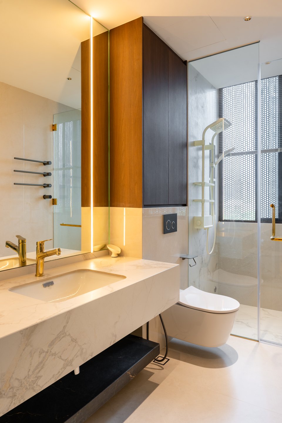 Bathroom layout planned from the door — white marble vanity, glass shower screen and wall-hung toilet in a Kuala Lumpur condominium bathroom