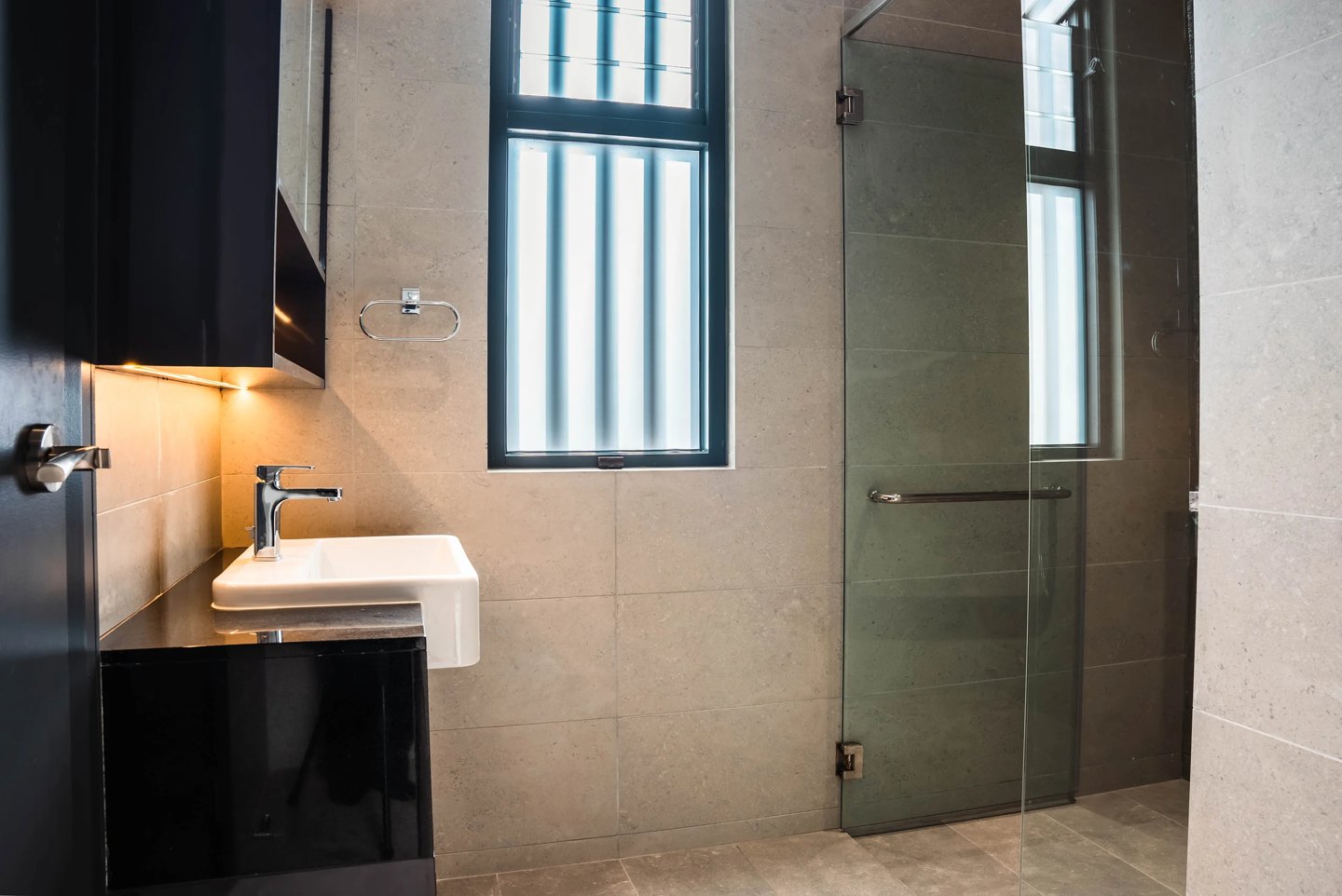 Walk-in shower with a frameless glass screen and wall-hung sink in a compact Cyberjaya bathroom, Setia Marina One