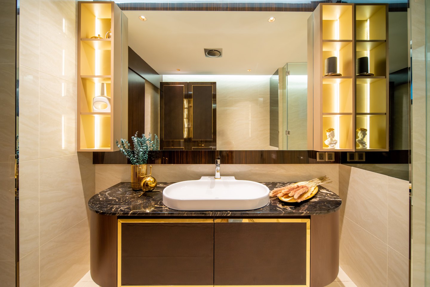 Wall-to-wall bathroom mirror above a dark stone vanity with backlit niches in a Bangsar bungalow ensuite