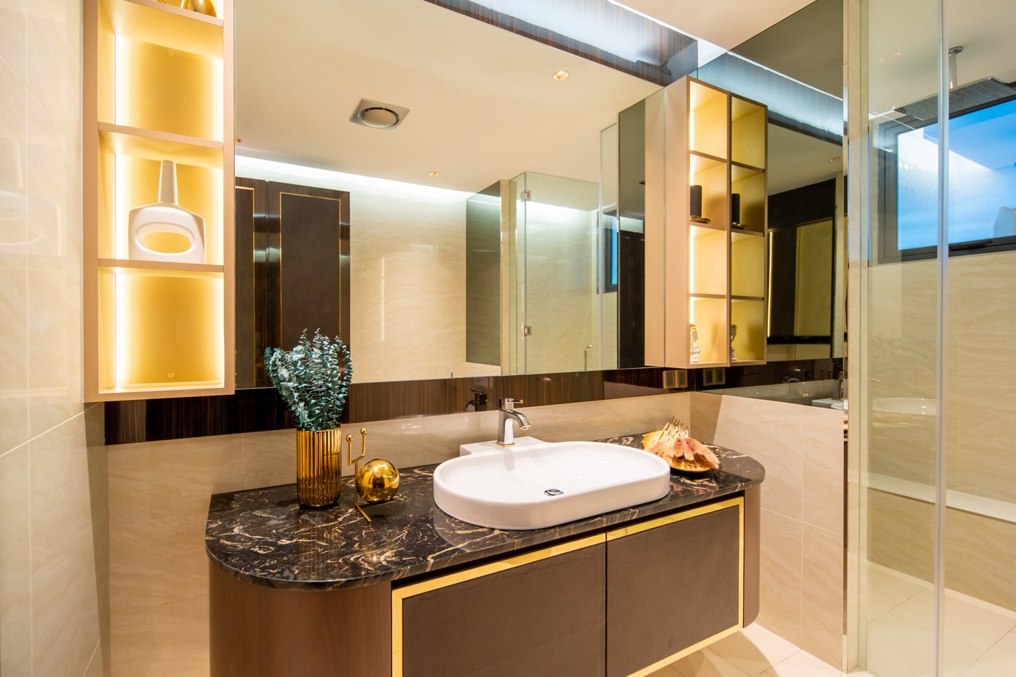 Vertical bathroom storage — backlit niches and mirrored cabinets beside the vanity in a Bangsar bungalow ensuite