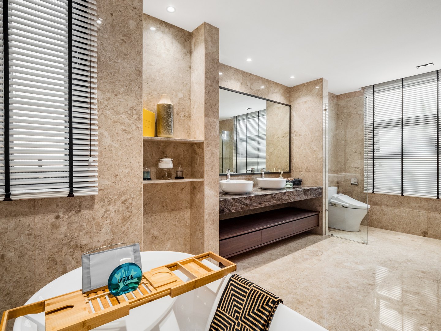 Honed travertine floor and wall tiles with a bathtub tray and blinds in a Kelana Jaya bungalow master bathroom