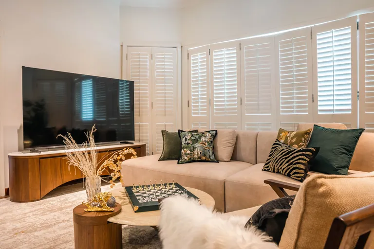 Bukit Tunku Residence, Kuala Lumpur: family lounge with plantation shutters and a curved timber TV console