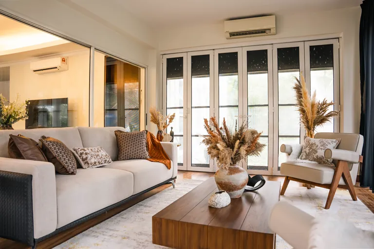 Bukit Tunku Residence, Kuala Lumpur: sitting room with a linen sofa and dried-grass styling