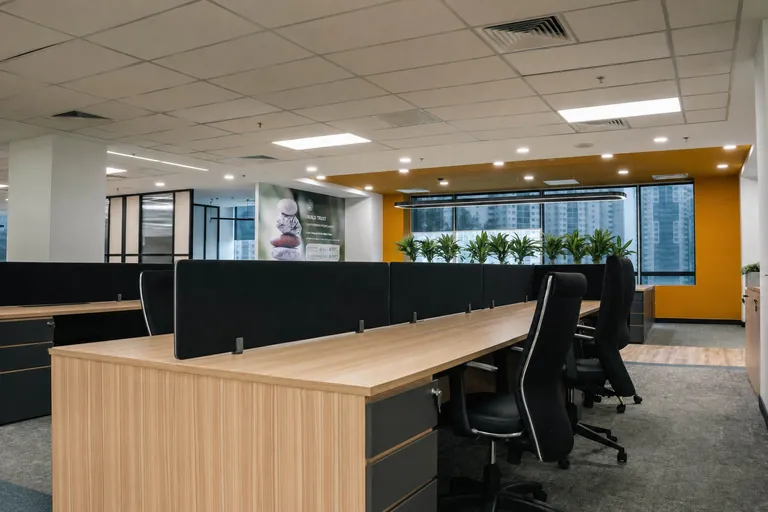 Persada PLUS Office, Petaling Jaya: open-plan workstations with timber desks and an orange feature wall
