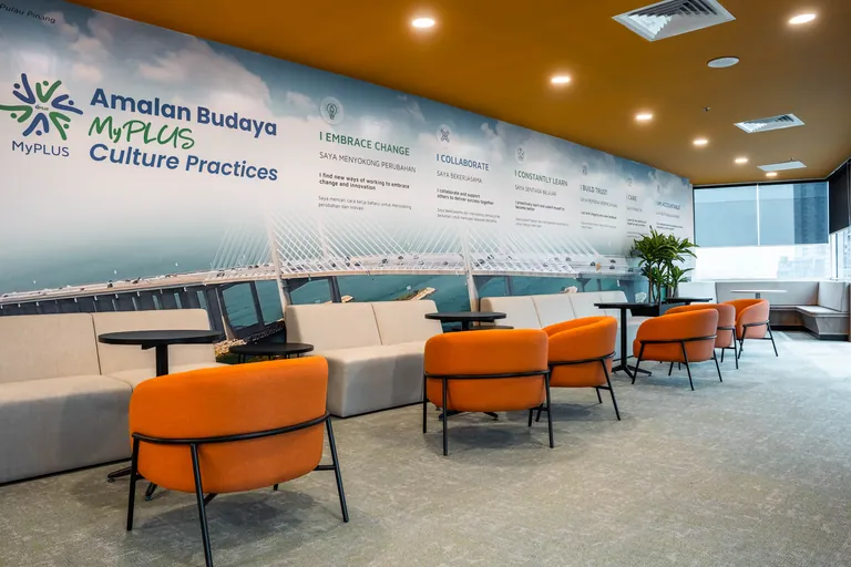 Persada PLUS Office, Petaling Jaya: lounge with orange armchairs and the MyPLUS culture wall