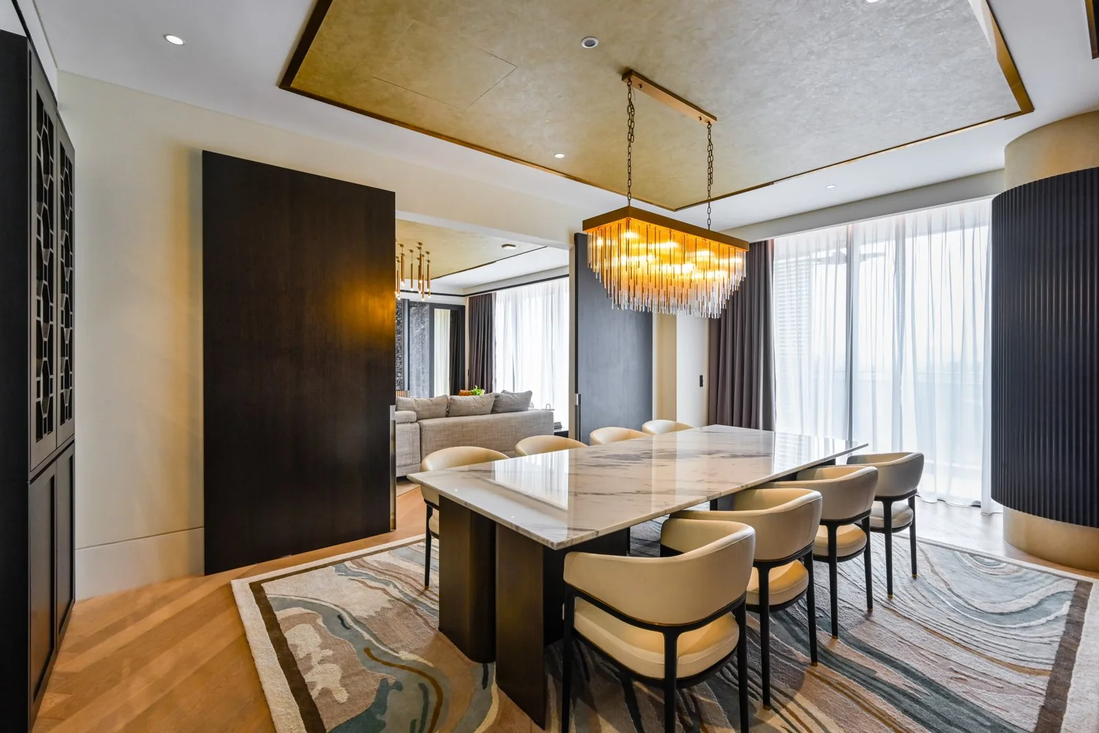 Gold-leaf tray ceiling with a crystal chandelier over the dining table at Aira Residence, Damansara Heights