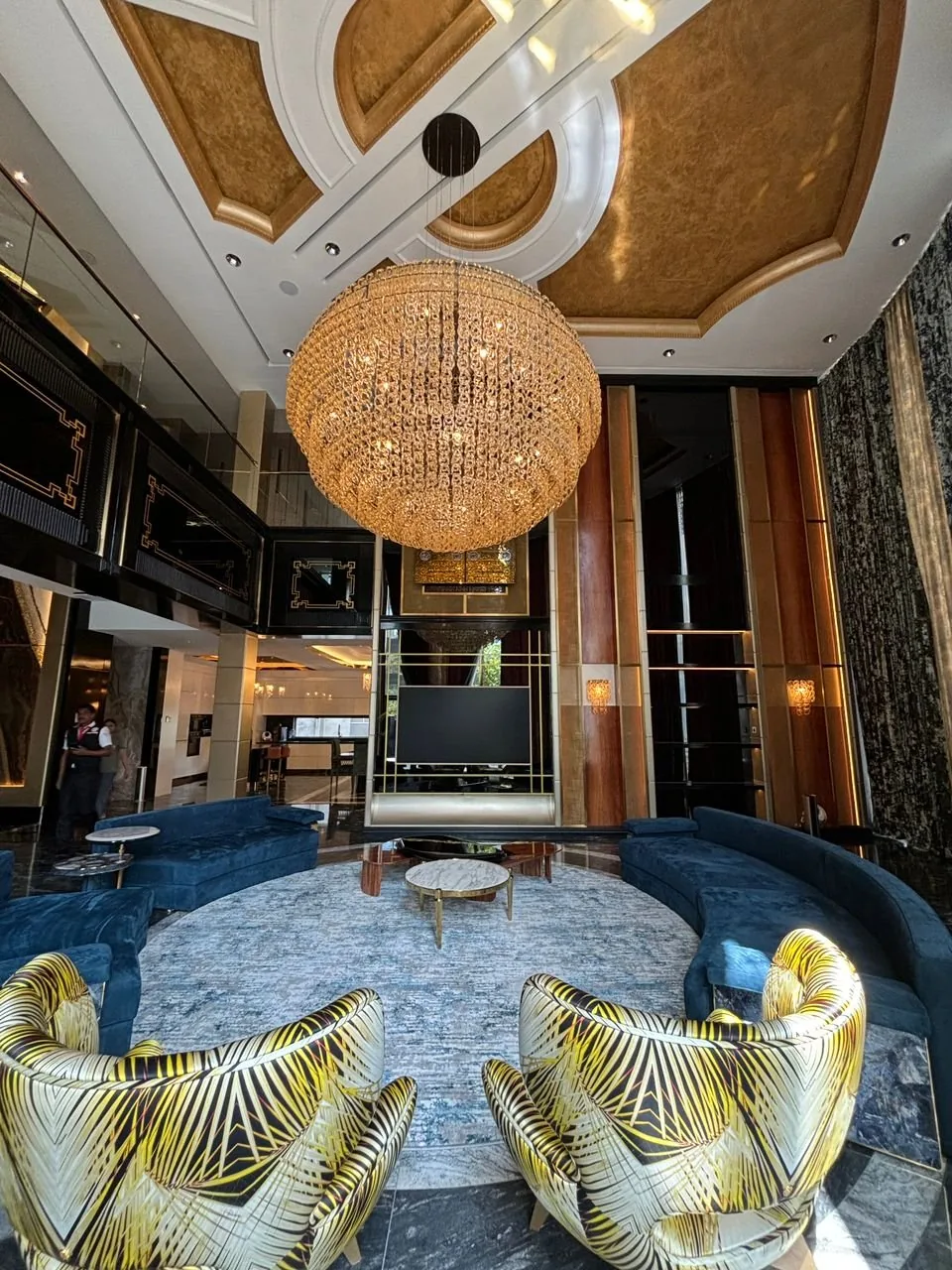 Gold coffered ceiling with a crystal globe chandelier over a lounge at The Peak, Ampang