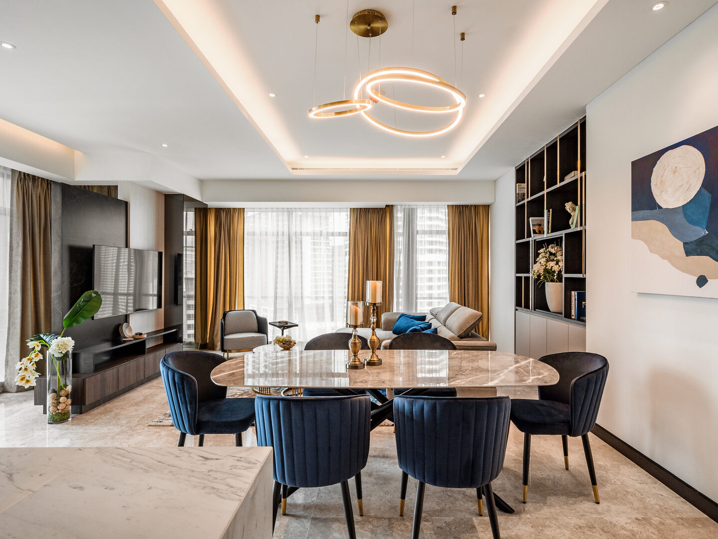 Condo dining area anchored by a marble table and a statement chandelier