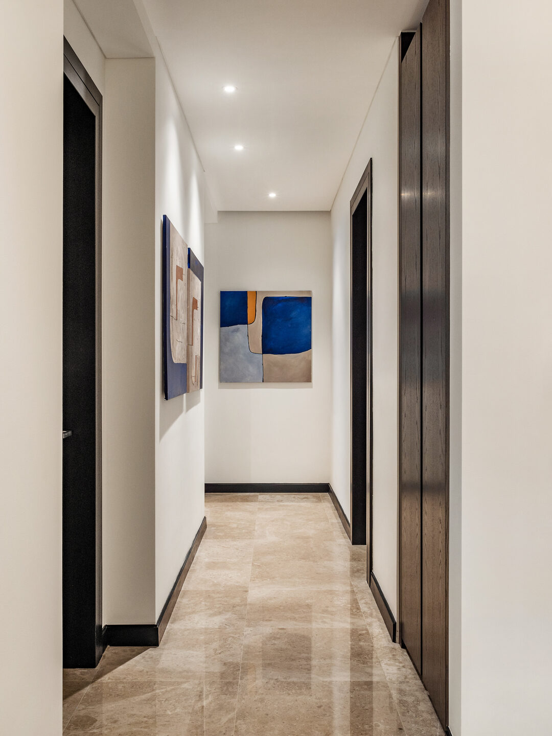 Condominium corridor with marble flooring and full-height timber doors