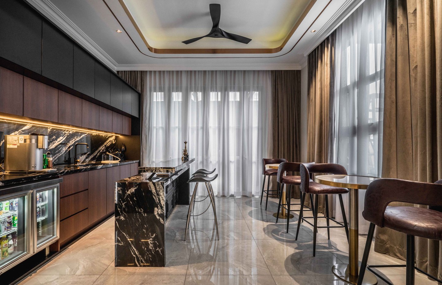 Dark-toned dry kitchen with a black marble island, bar seating and backlit cabinetry in an EcoSpring landed home, by Blaine Robert Design