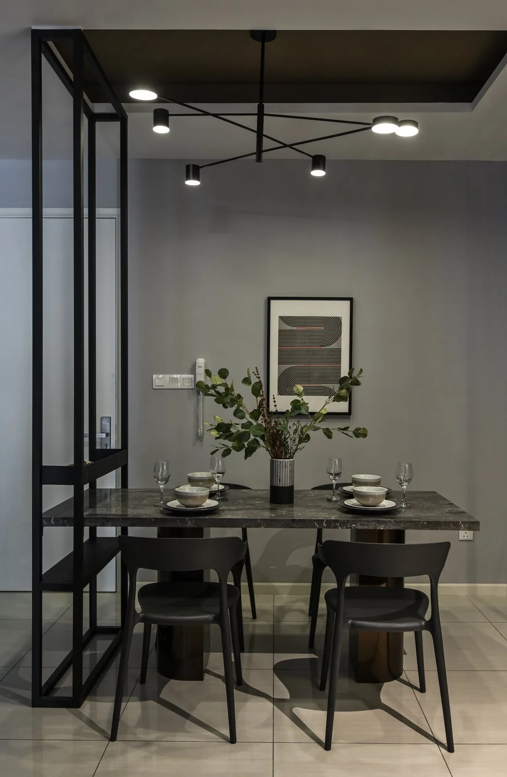 Dining space with a dark table and a black steel framed partition at the Dorsett Hartamas show unit