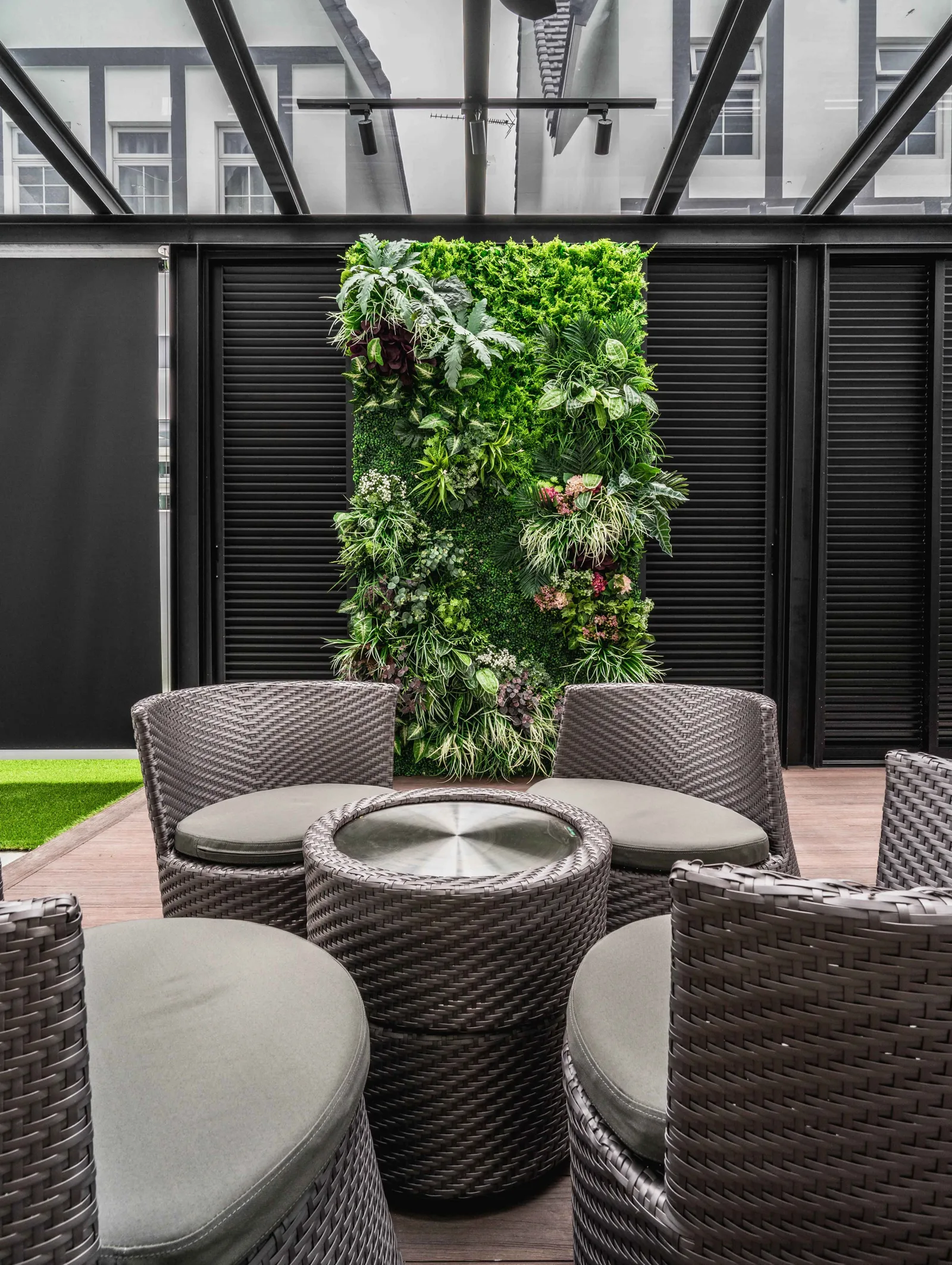 Pocket garden with a green wall and outdoor seating under a glass roof, EcoSpring Villa, Johor Bahru