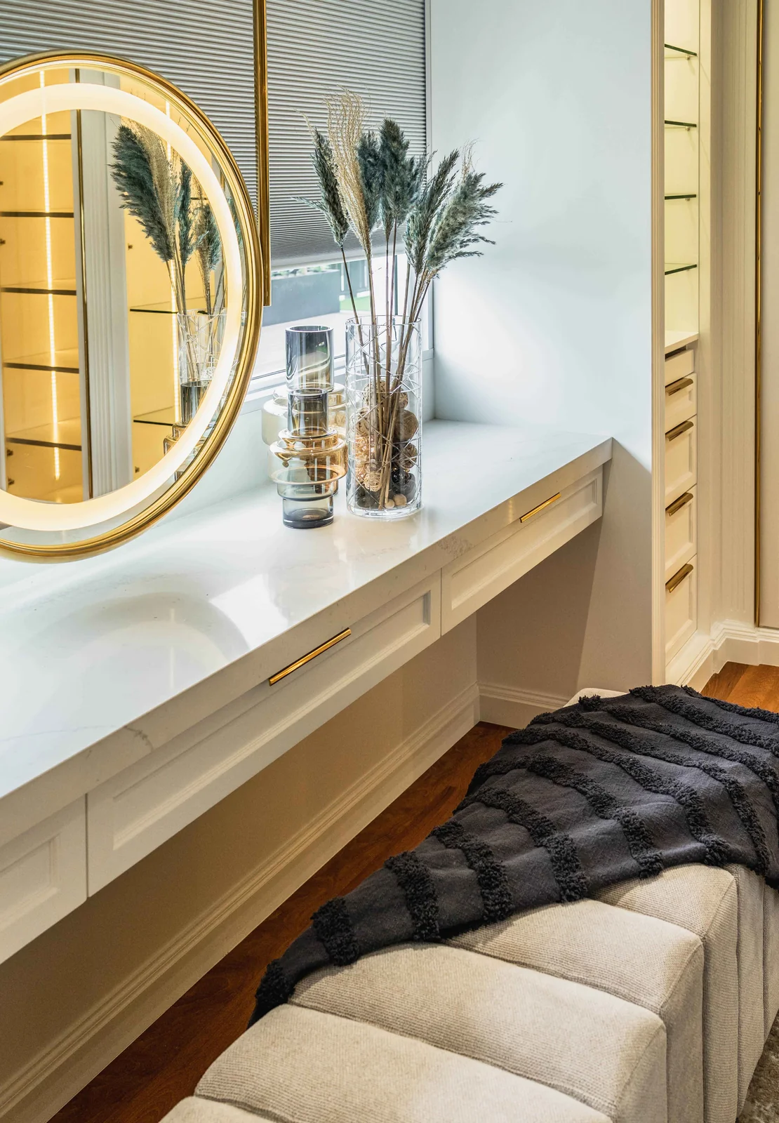 Dressing table and backlit round mirror inside a walk in wardrobe, Eco Spring bungalow