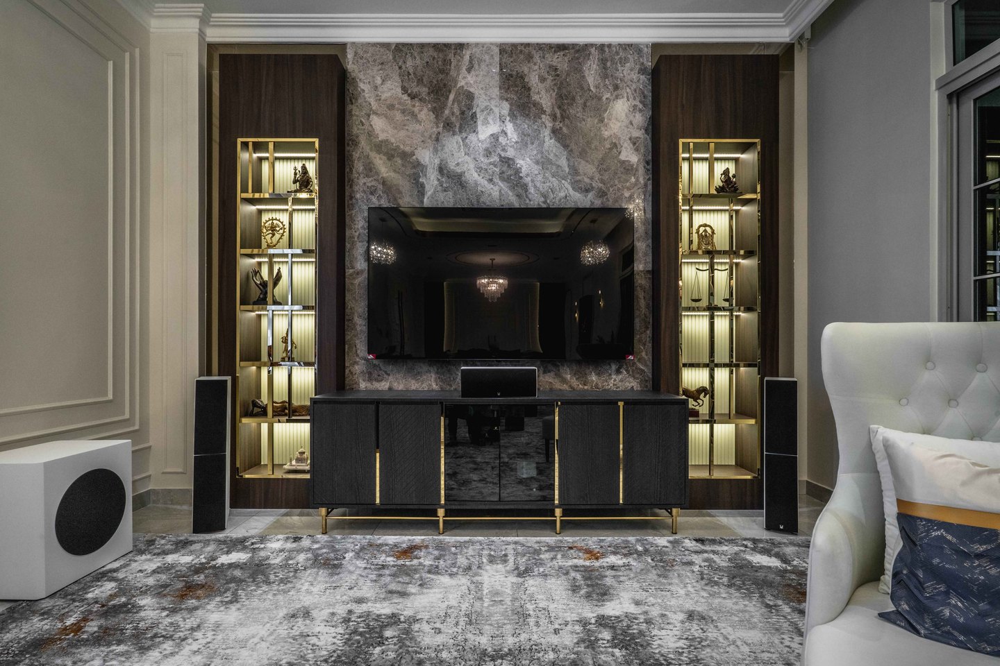 Grey marble TV feature wall with brass display niches in the family lounge of an EcoSpring residence