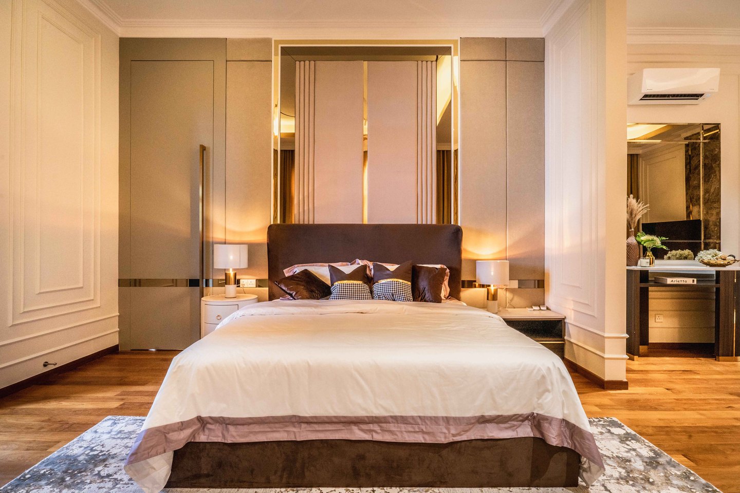 Bedroom feature wall of cream panels, mirror strips and gold trim at an EcoSpring residence