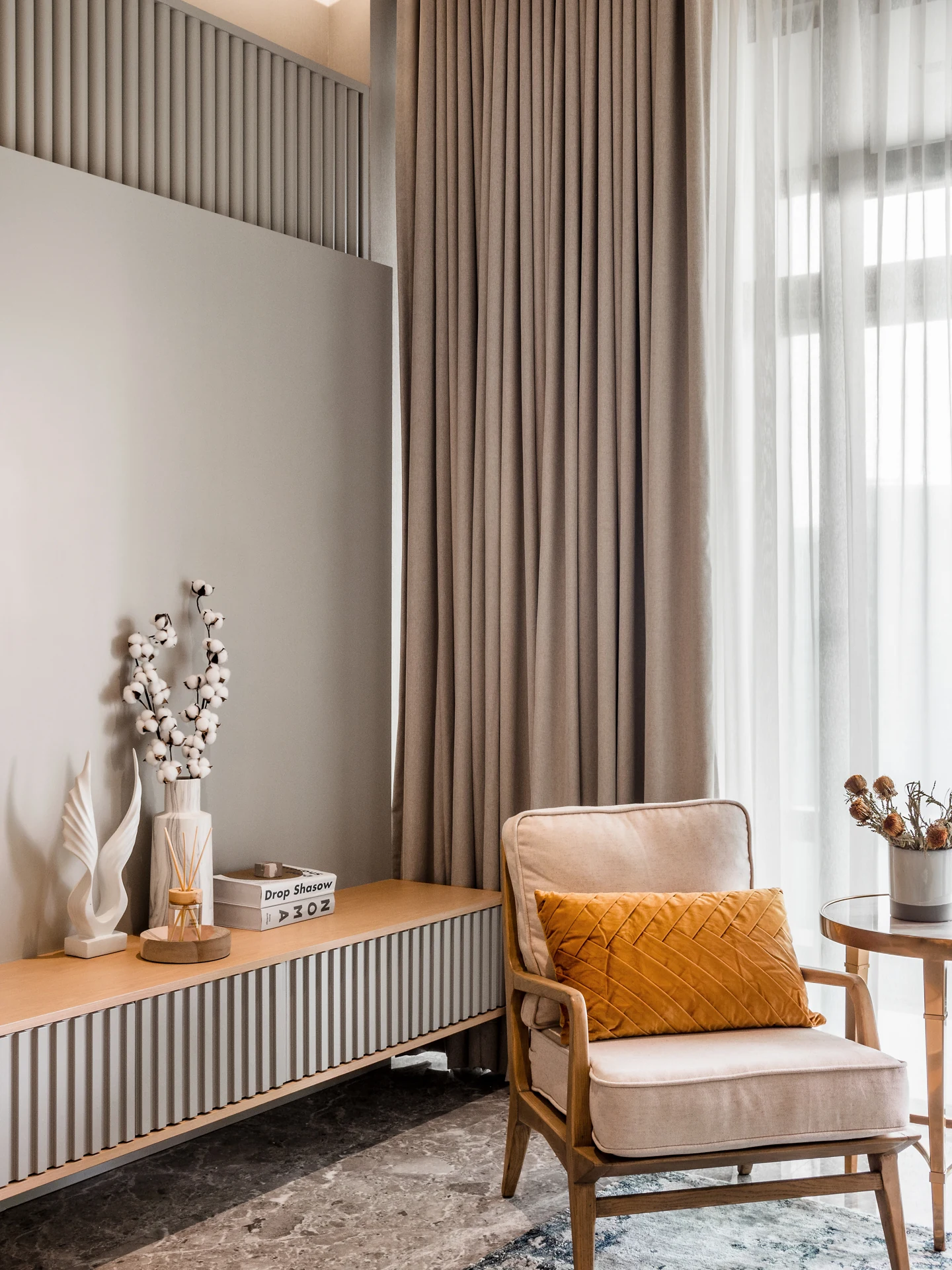 Reading corner with accent armchair and fluted sideboard in a living hall at Four Seasons Residences, KLCC.