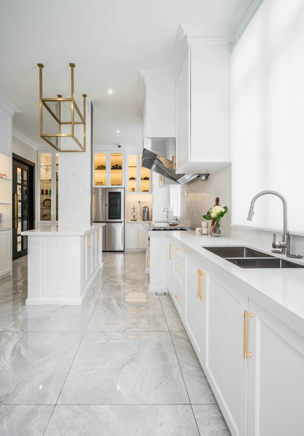 White galley kitchen with a full-height fridge, sink run and cooker hood in an EcoSpring landed home, designed and built by Blaine Robert Design