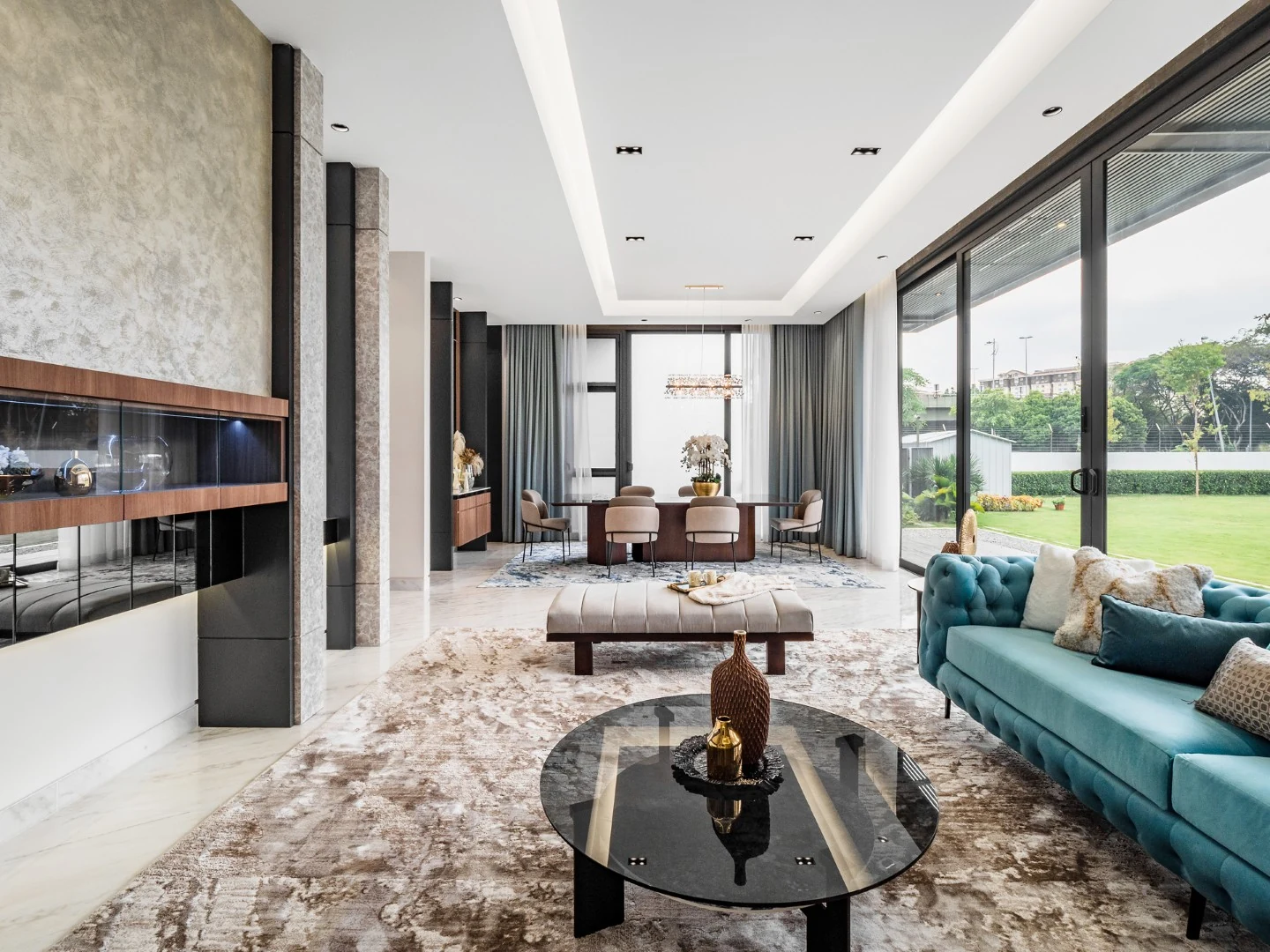 Wide living hall of a Kelana Jaya bungalow with a large rug zoning the seating on marble flooring.