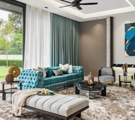 Teal tufted chesterfield sofa and daybed in the living hall of a Kelana Jaya bungalow featured in Tatler Asia, with garden views through full-height glazing.