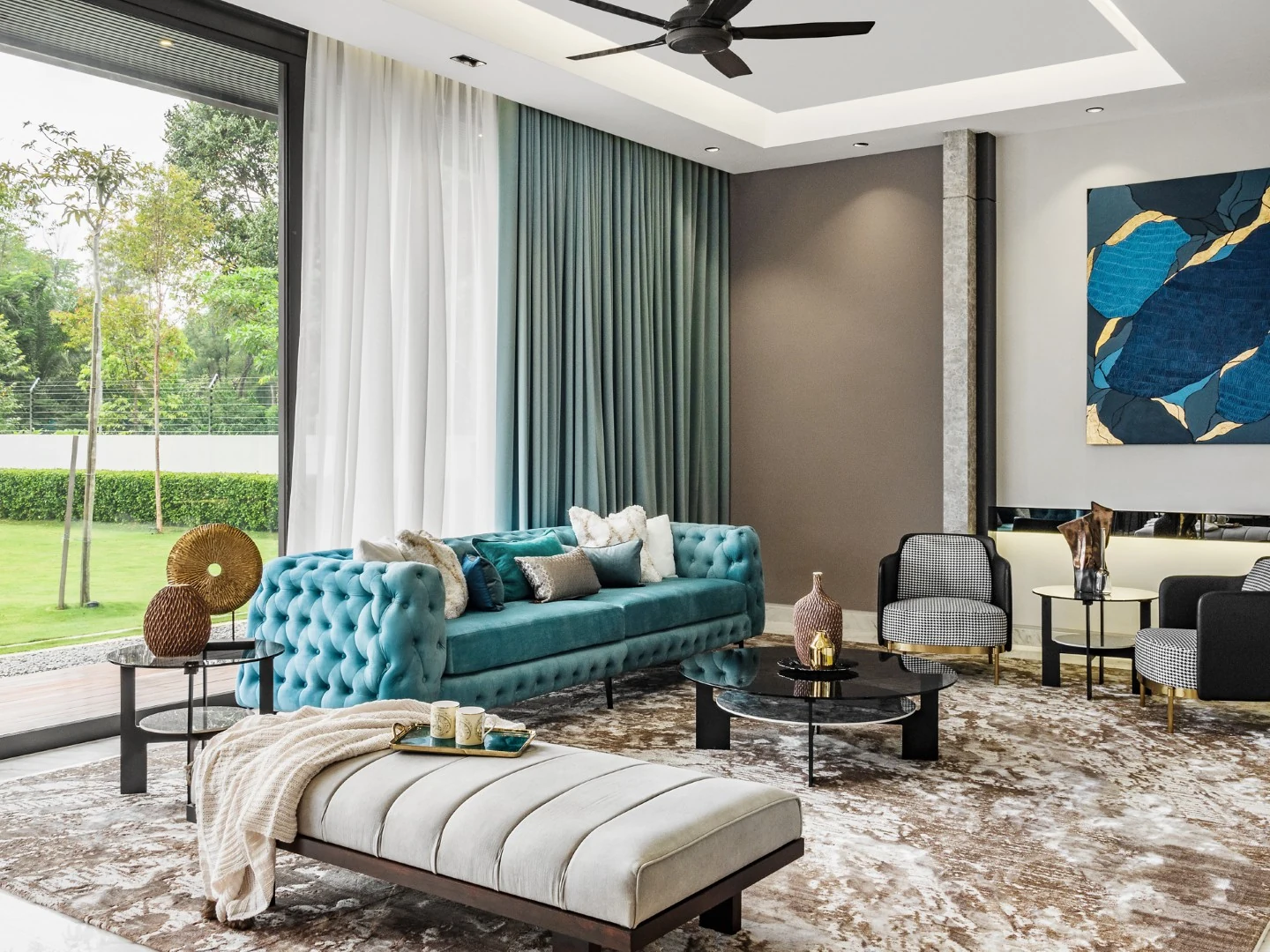 Teal tufted chesterfield sofa and daybed in the living hall of a Kelana Jaya bungalow featured in Tatler Asia, with garden views through full-height glazing.