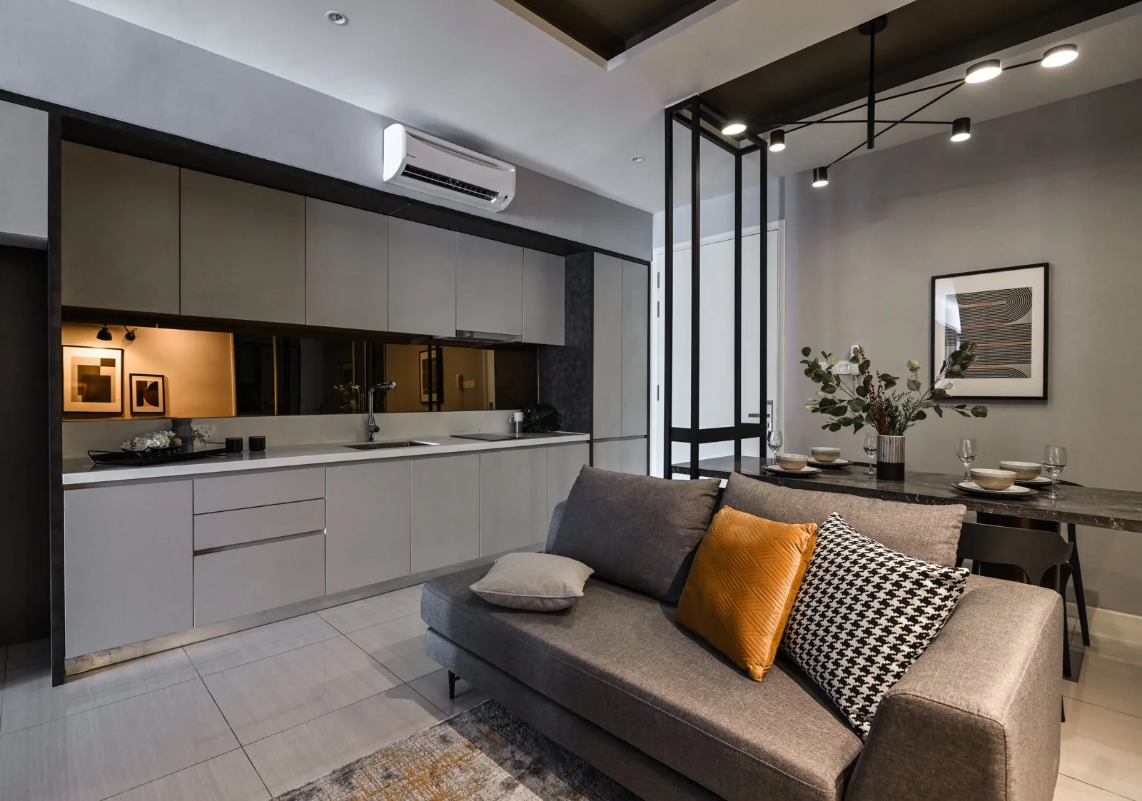 Grey flat-panel kitchen cabinets along one wall of the Dorsett Hartamas show unit, Kuala Lumpur, open to the living room