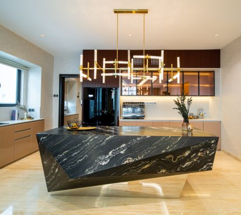Kitchen design in Malaysia — black marble waterfall island under a linear brass pendant in the open-plan kitchen of a Bangsar bungalow, designed and built by Blaine Robert Design