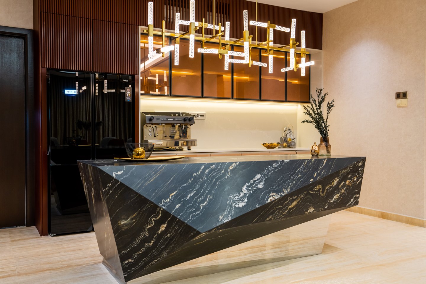 Kitchen island with a black stone waterfall edge and brass-trimmed cabinetry, Bangsar bungalow, by Blaine Robert Design