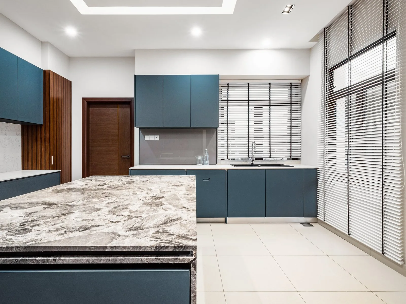 Stone kitchen island countertop and navy drawers seen from the working side at East Coast Villa