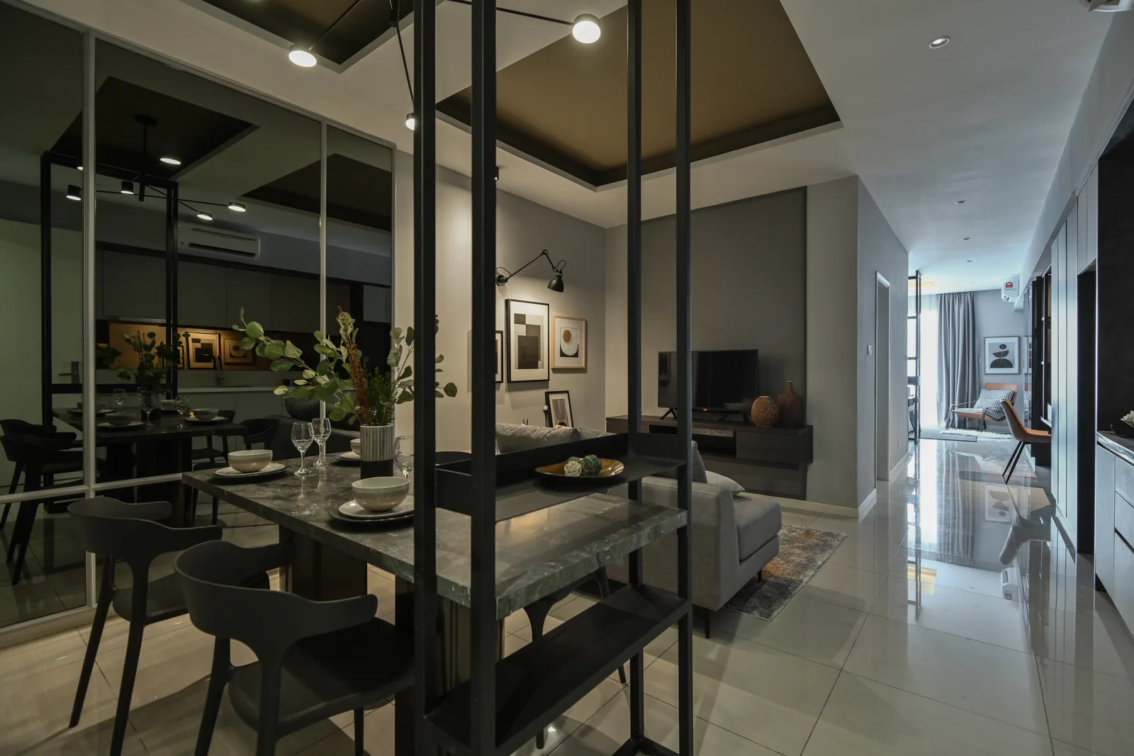 Track spotlights over a dining table beside a glass partition in the Dorsett Hartamas show unit, Sri Hartamas
