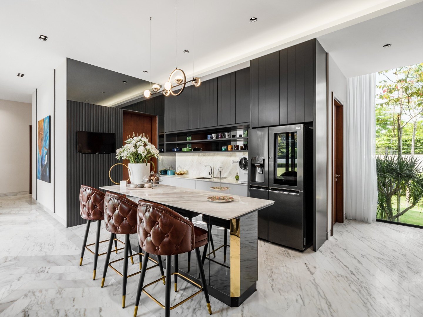 L-shaped kitchen design with dark cabinets, marble-topped island and leather bar stools in a Kelana Jaya bungalow featured in Tatler Asia, by Blaine Robert Design