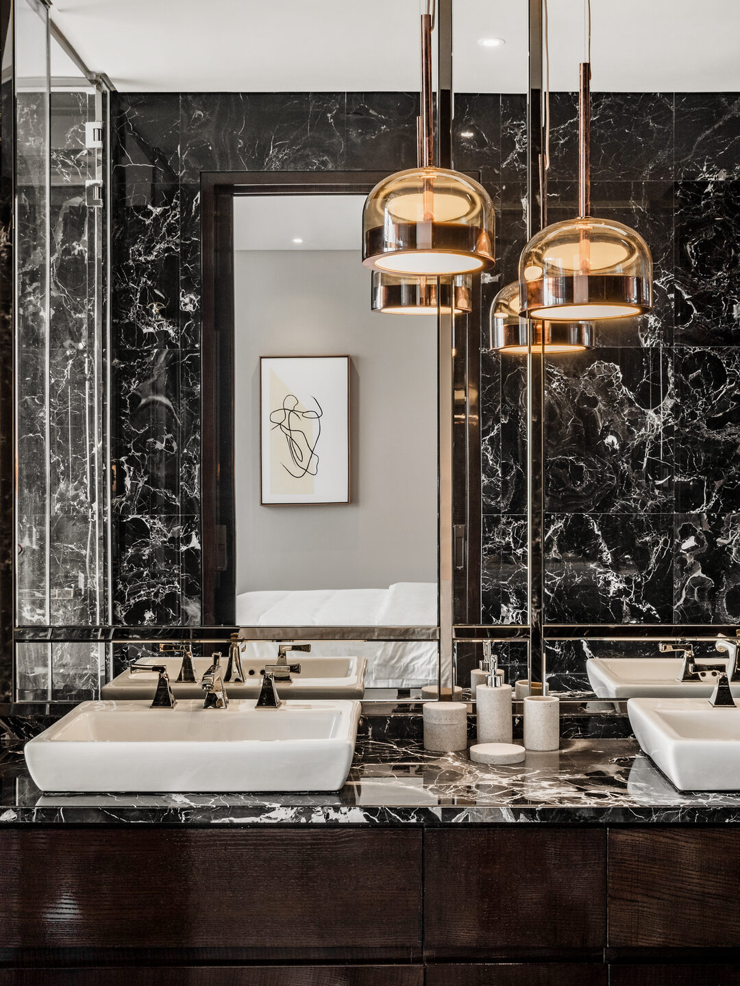 Marble condo bathroom with double vanity and brass pendant lights