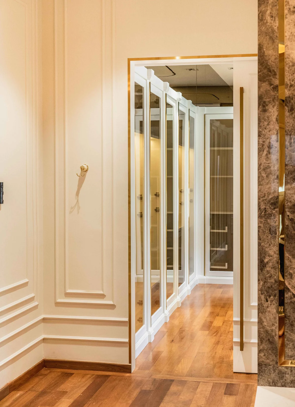 Mirrored wardrobe doors along a dressing corridor in a Blaine Robert Design bungalow