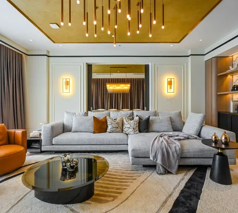 Modern contemporary interior design in Malaysia — warm-neutral living room with a curved leather chair, backlit shelving and a gold-leaf ceiling at Aira Residence, Damansara Heights, by Blaine Robert Design