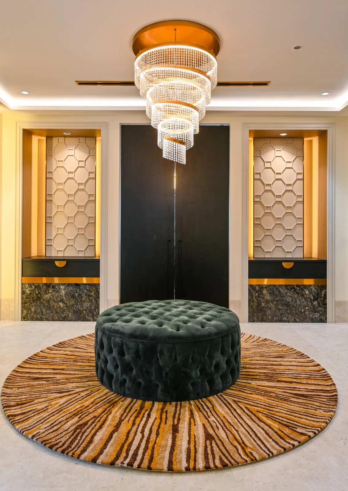 Entrance foyer with a tiered chandelier and a round ottoman at Aira Residence, Damansara Heights