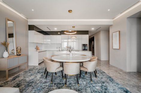 Open-plan kitchen behind the dining area of a three-room apartment at Four Seasons Place, Kuala Lumpur, designed by Blaine Robert Design