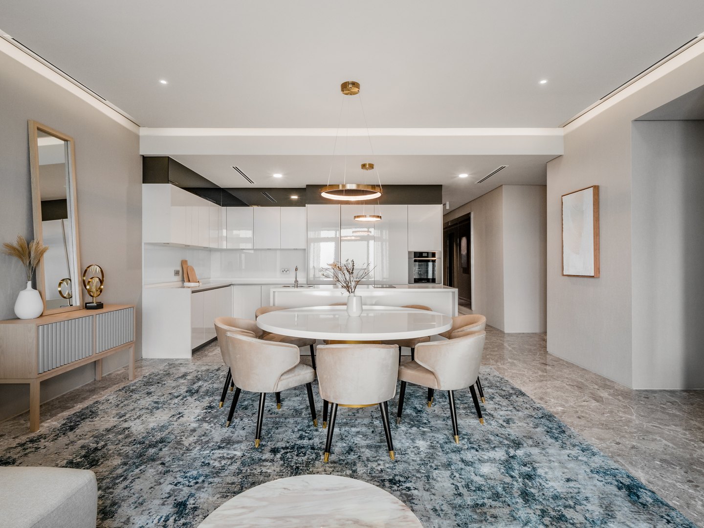 Open-plan kitchen behind the dining area of a three-room apartment at Four Seasons Place, Kuala Lumpur, designed by Blaine Robert Design