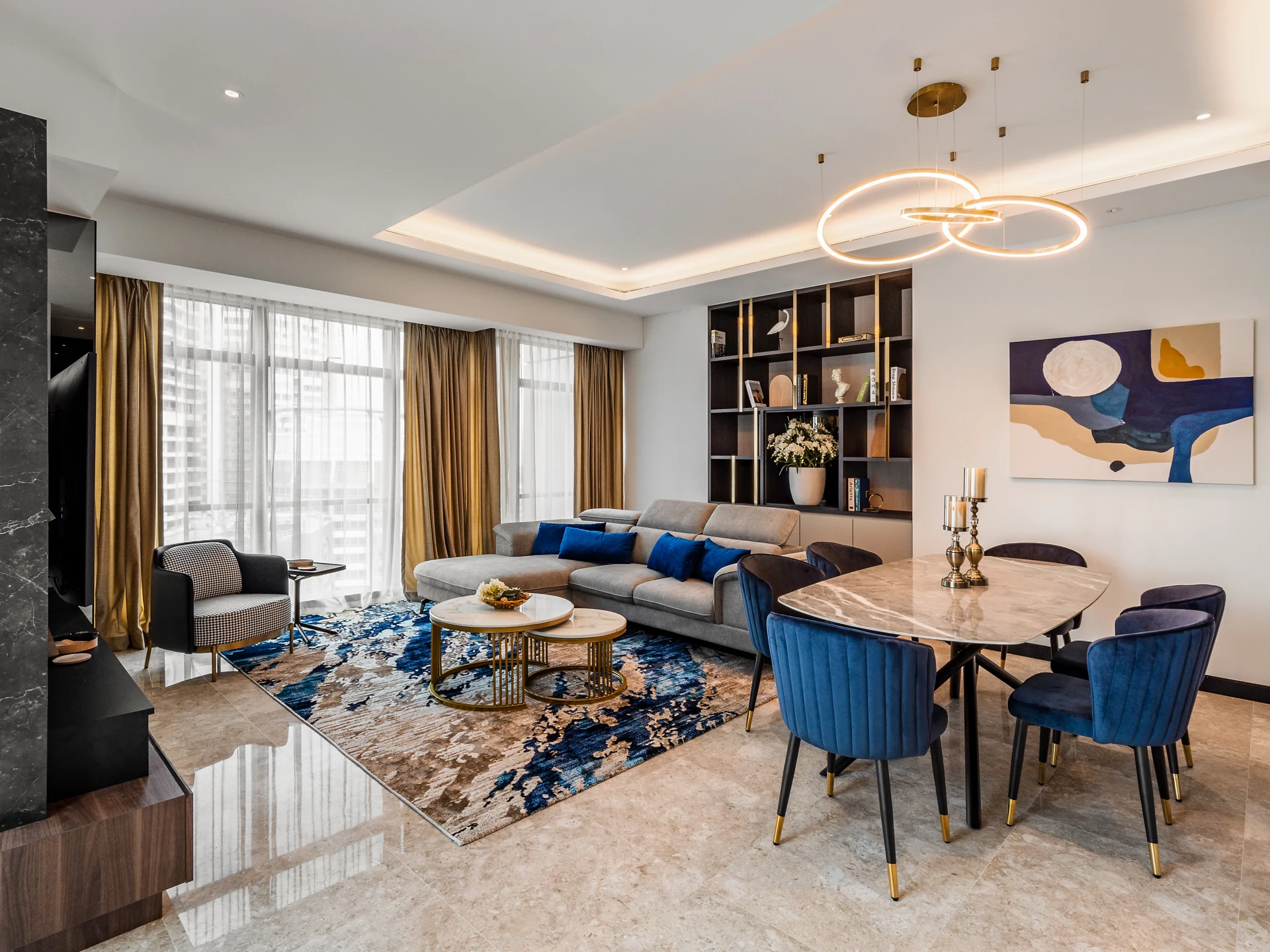 Open-plan living hall of a high-rise residence at the Ritz-Carlton Residences, Kuala Lumpur — sectional, dining table and display shelving in one footprint.