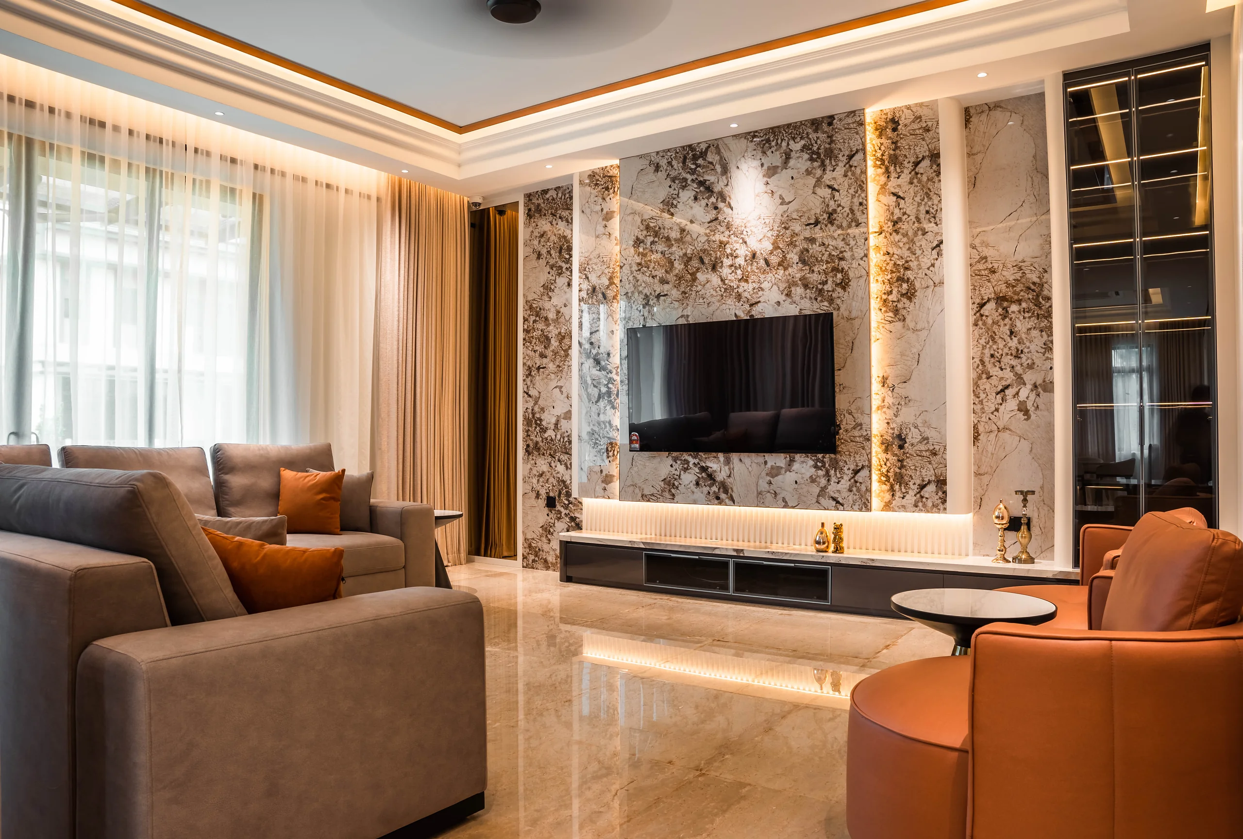 Wall-mounted TV on a backlit marble feature wall in the family lounge at Setia Marina One, Cyberjaya.
