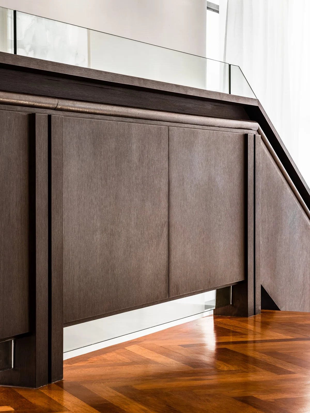 Timber-clad balustrade topped with a glass panel and a timber handrail at the East Coast Villa, Terengganu