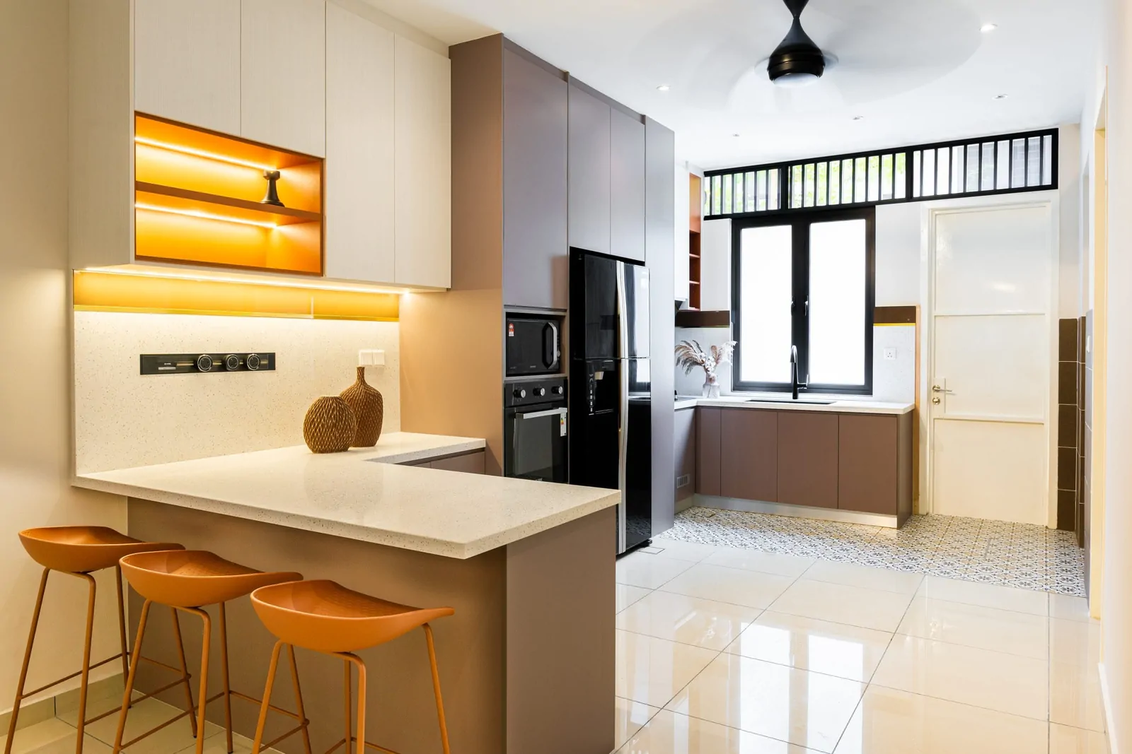 Terrace house dry kitchen with a breakfast bar, backlit shelving and a window to the rear, Serimba Residence, Kajang