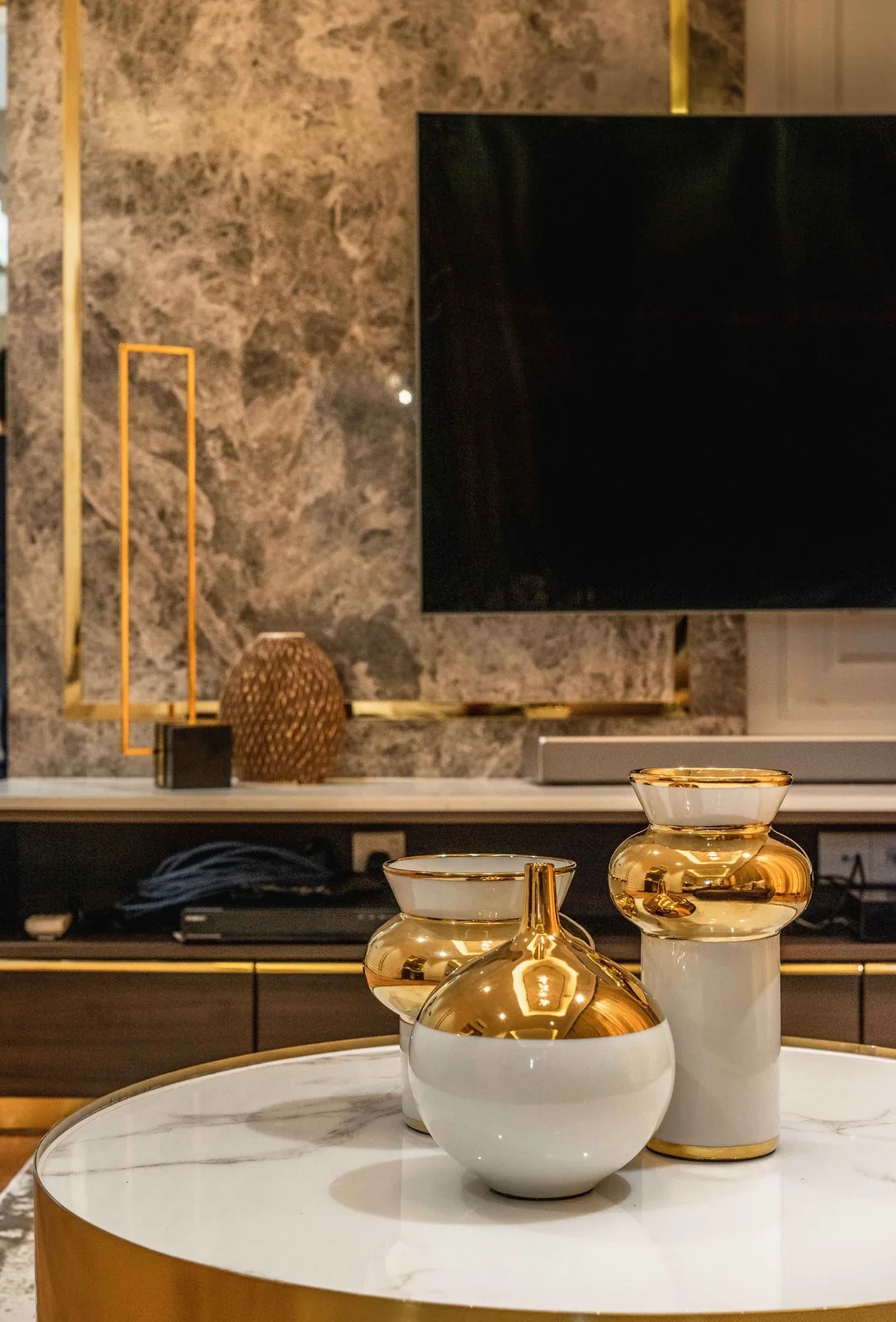 Floating TV console with brass detail under a marble panel at EcoSpring, Johor Bahru