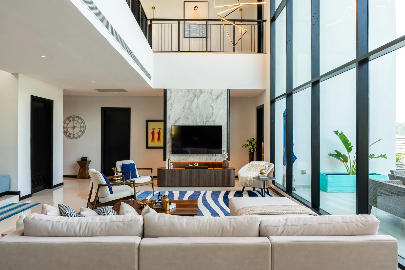 Double-height living room with a marble TV wall at Quayside Villa, Port Dickson