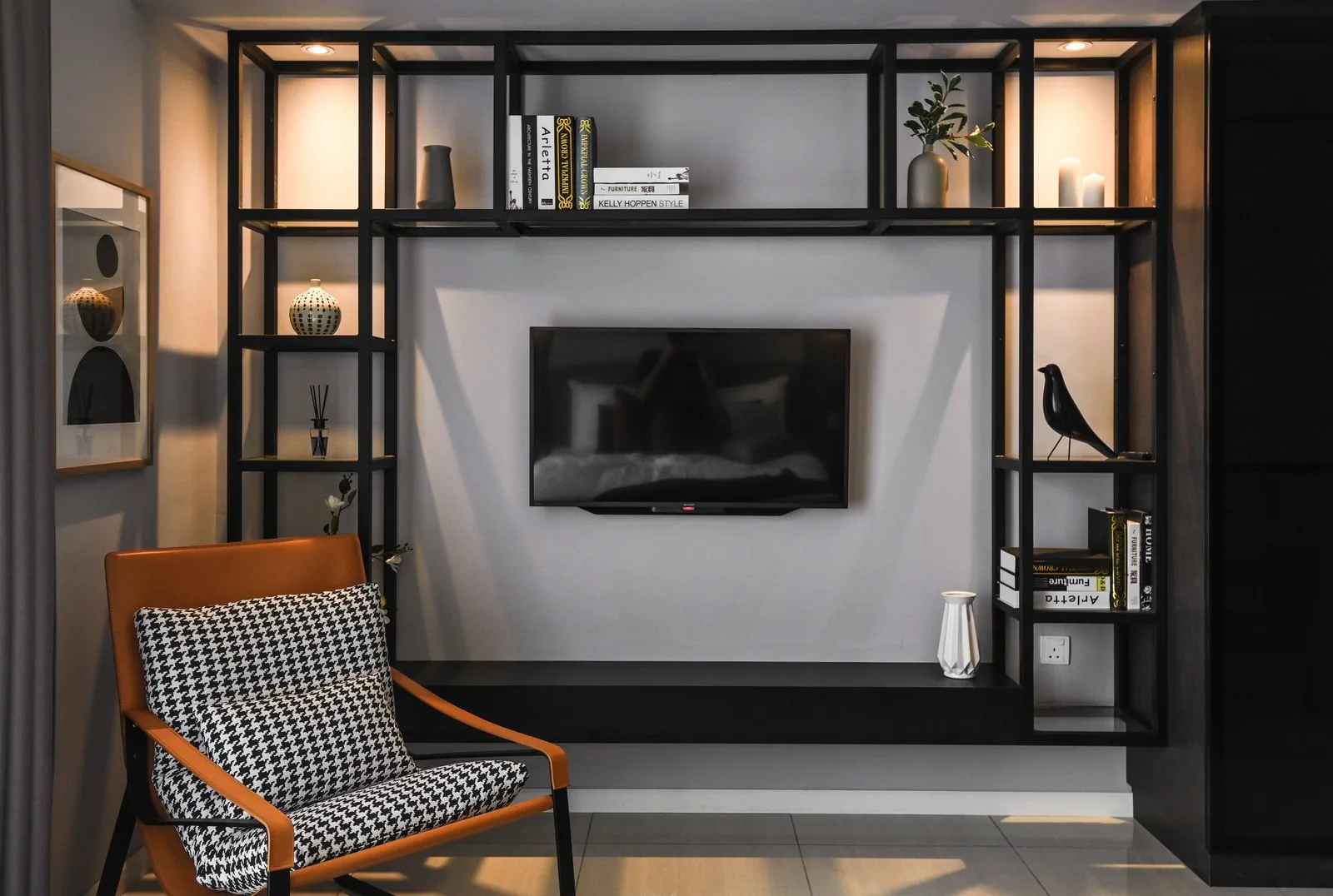 Bedroom TV wall framed by black open shelving in the Dorsett Hartamas show unit