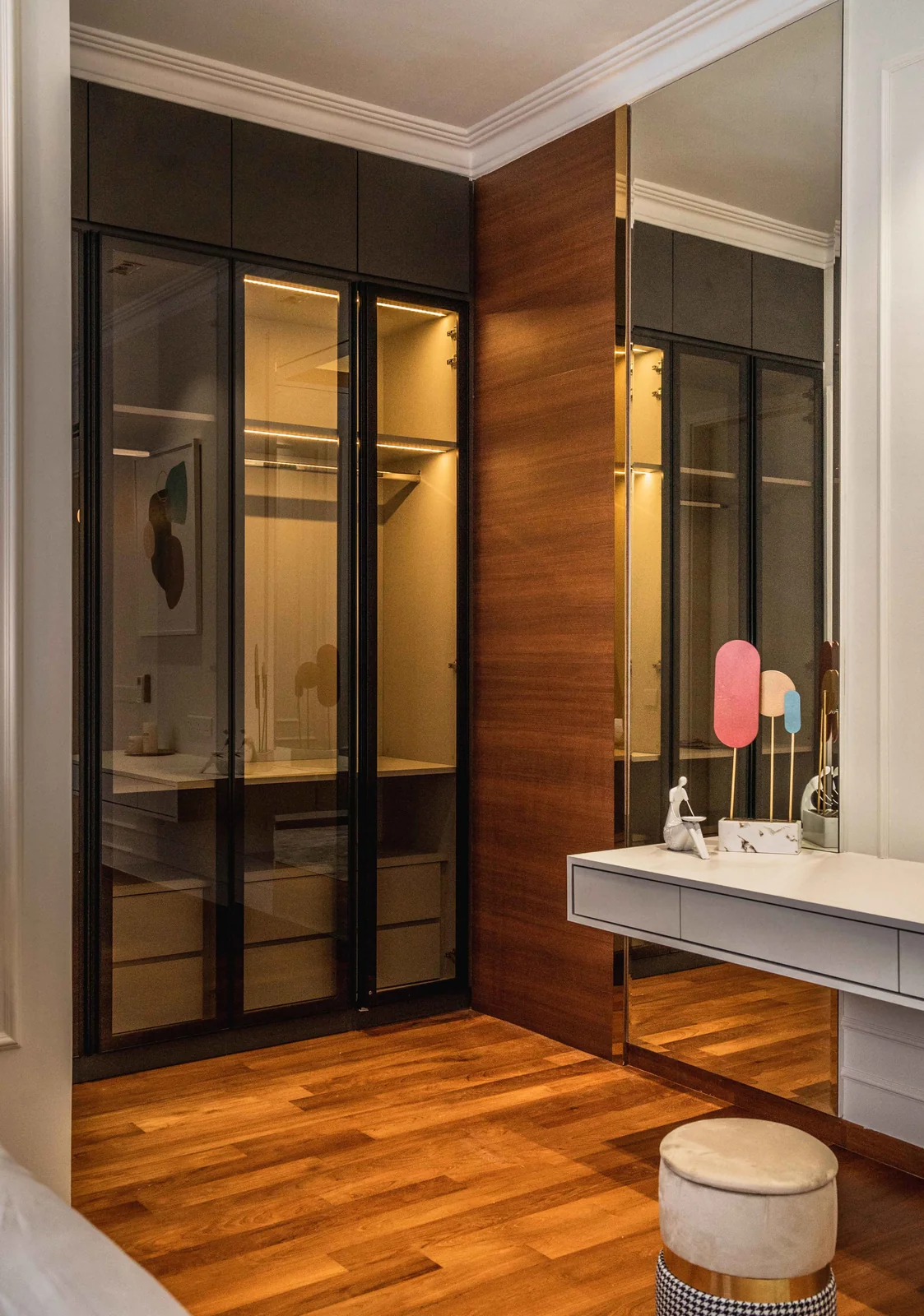 Vanity beside a glass-door wardrobe in a bedroom by Blaine Robert Design