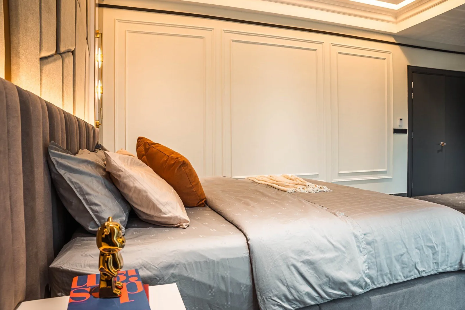 Floor-to-ceiling wainscoting panels with applied molding behind a bed at Setia Marina One, Cyberjaya