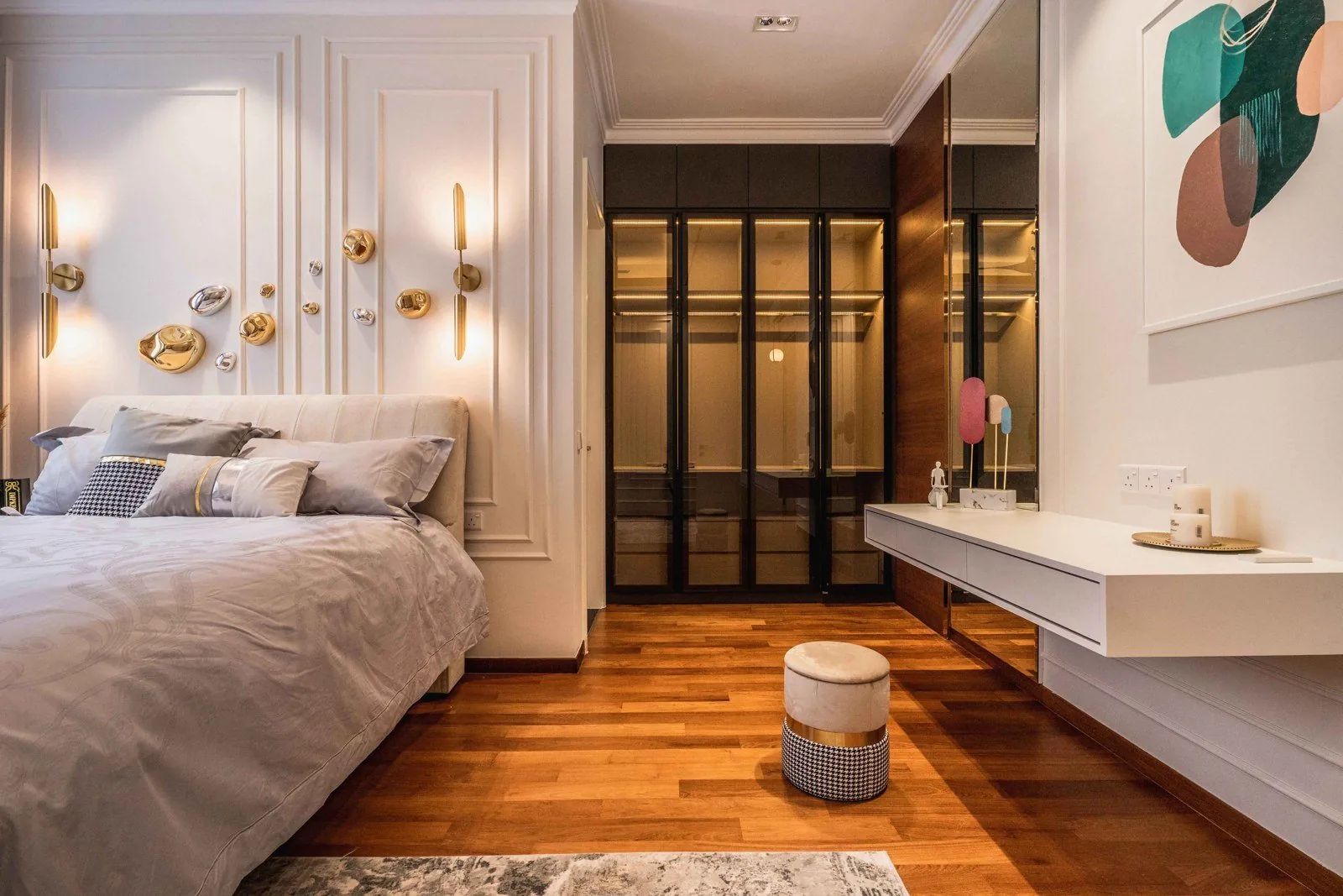 White wainscoting panels behind a bed with brass wall lights at EcoSpring
