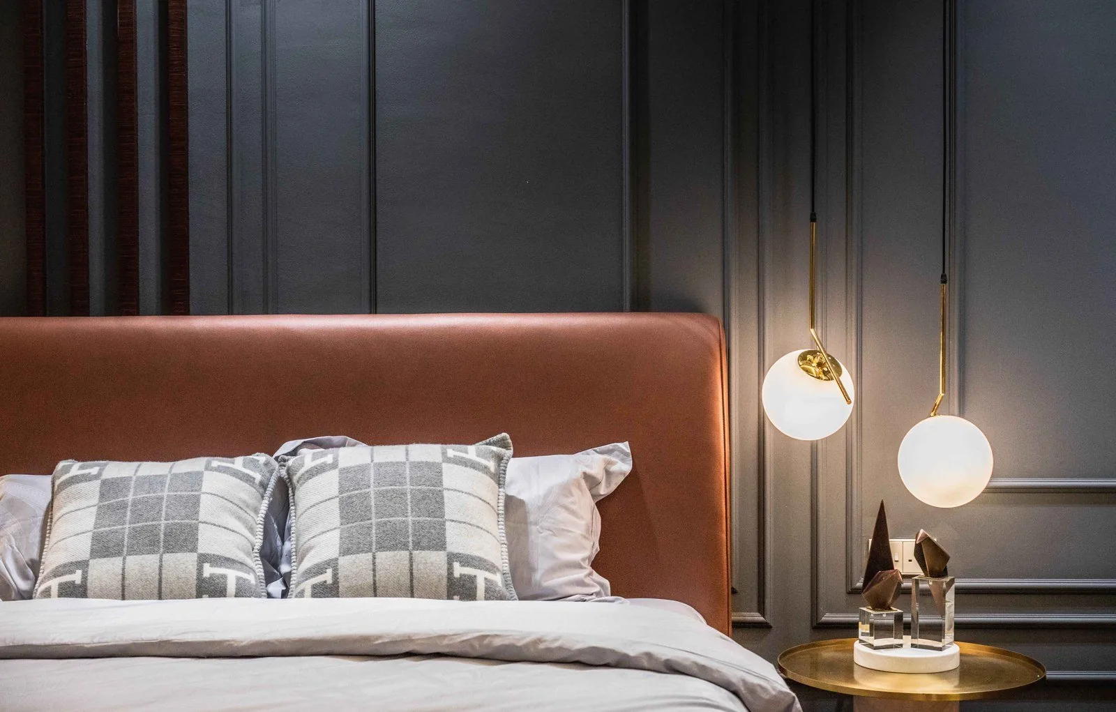 Close view of dark painted wainscoting panels behind a leather headboard at EcoSpring