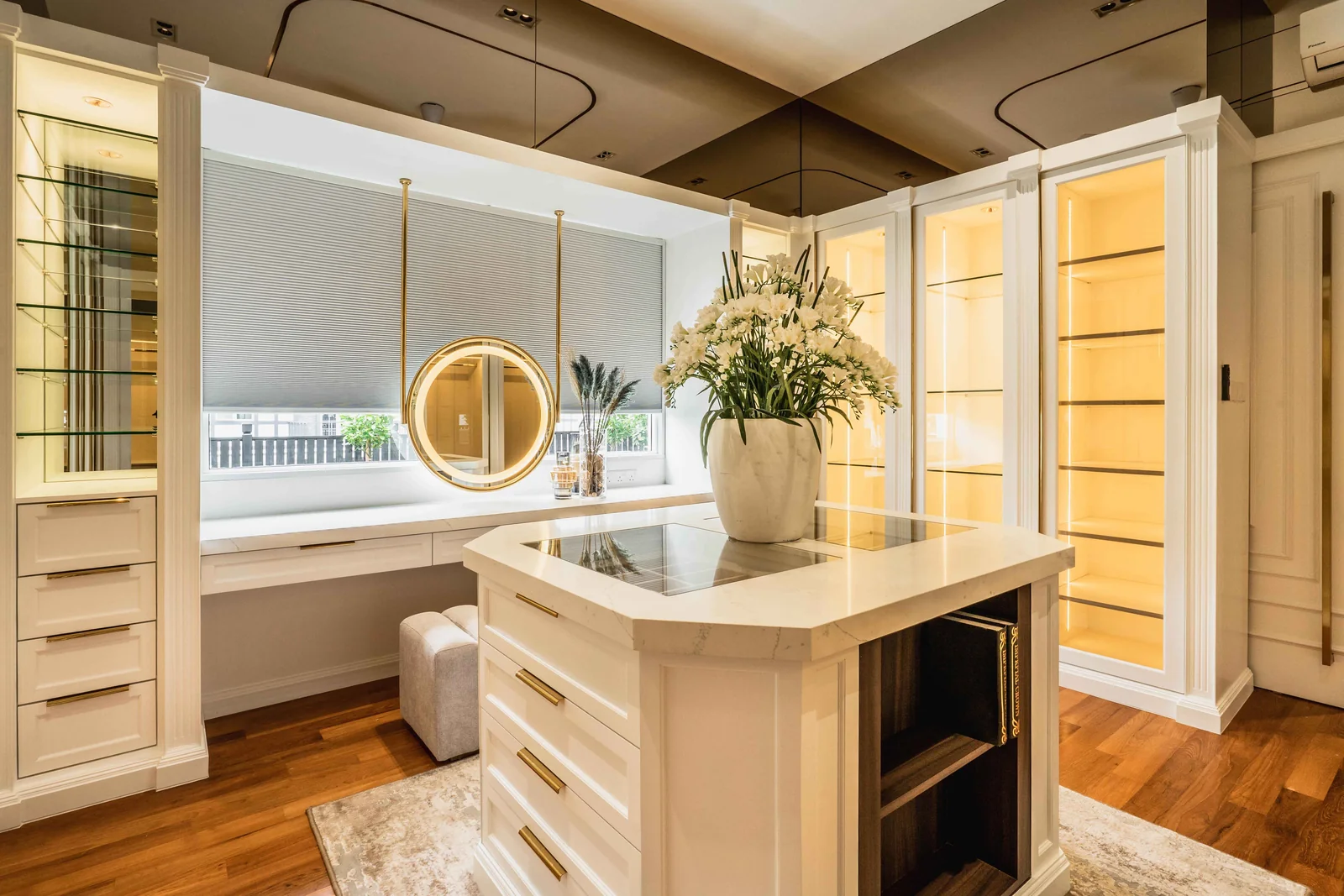 U-shaped walk in closet with round mirror and lit glass cabinets, Eco Spring bungalow by Blaine Robert Design