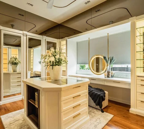 Lavish walk in wardrobe with a central island and glass display cabinets in a Blaine Robert Design bungalow at Eco Spring, Johor